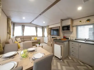 a kitchen and living room with a table in a caravan at Beautiful Cosy Holiday Home in Gorgeous Location - Pass the Keys in Beattock