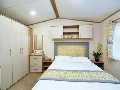 a bedroom with a large white bed and a mirror at Beautiful Cosy Holiday Home in Gorgeous Location - Pass the Keys in Beattock