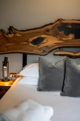a bed with a wooden headboard and two pillows at The Eyrie in Keswick