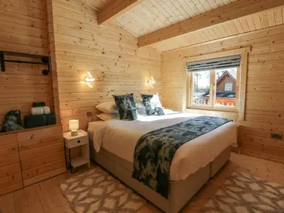 a bedroom with a bed in a log cabin at Little Lodge in Newton Stewart