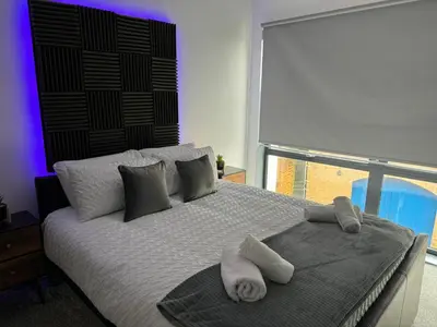 a bedroom with a large bed with towels on it at Quayside Apartment -2 Bedrooms - Sleeps 4 in Whitehaven