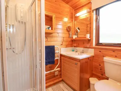 a bathroom with a shower and a sink and a toilet at Hayeswater Lodge in Keswick
