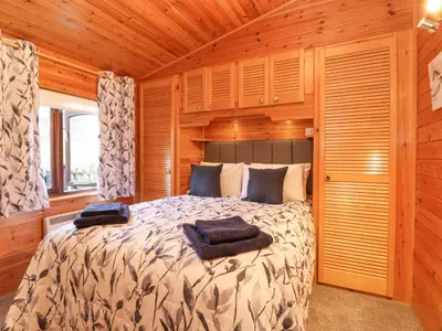 a bedroom with a bed in a wooden room at Hayeswater Lodge in Keswick