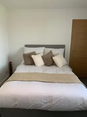 a bed with four pillows on top of it at Dumfries Apartment 2 in Dumfries