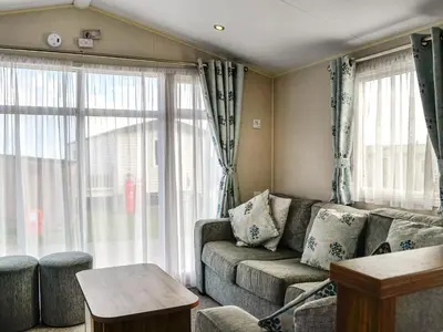 a living room with a couch and large windows at Sea View 59 - Uk45586 in Mainsriddle