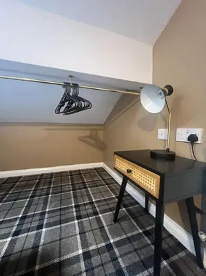a desk with a lamp on it in a room at Tynwald Apartments in Douglas