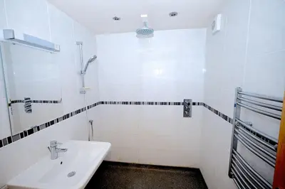 a white bathroom with a sink and a shower at North Lake District rural retreat in Penrith