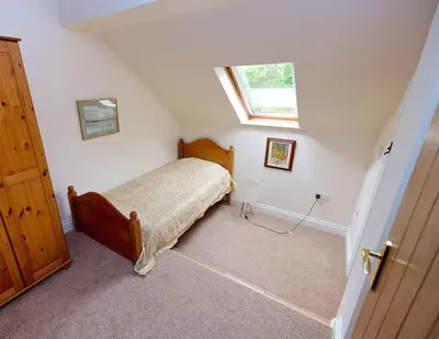 a bedroom with a bed and a window on the wall at North Lake District rural retreat in Penrith