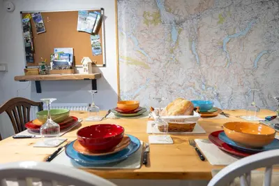 a wooden table with bowls and plates on it at Cottage On The Brook in Braithwaite