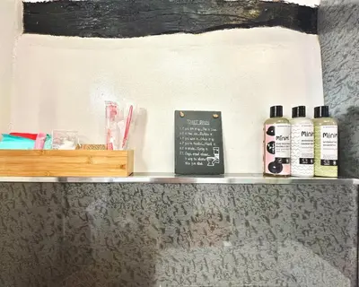 a shelf with three bottles of hair products on it at Cottage On The Brook in Braithwaite