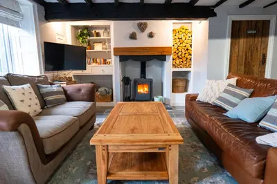 a living room with a couch and a fire place at Cottage On The Brook in Braithwaite