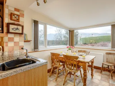 a kitchen with a table and chairs and a sink at 3 Bed in Portinscale 93949 in Portinscale