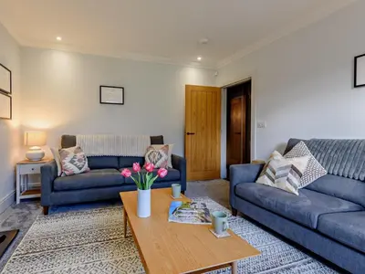 a living room with two blue couches and a coffee table at 3 Bed in Loweswater 94152 in Arlecdon