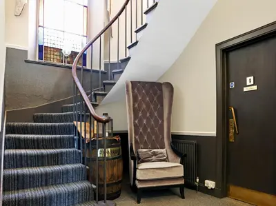 a stairway with a chair and a stair case at Dryfesdale Hotel - BW Signature Collection in Lockerbie