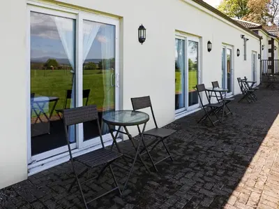 a patio with chairs and a table and windows at Dryfesdale Hotel - BW Signature Collection in Lockerbie