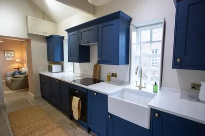 a kitchen with blue cabinets and a sink at The Tower in Carlisle