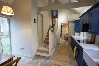 a kitchen with blue cabinets and a stairway at The Tower in Carlisle