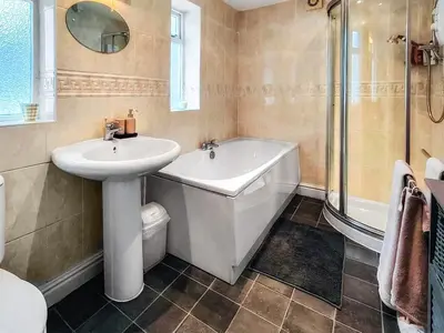 a bathroom with a sink and a bath tub and a toilet at Little Hills in Keswick