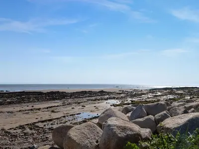 a group of rocks on a beach with the ocean at Sandy Paws - Uk45511 in Mainsriddle