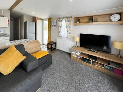 a living room with a couch and a flat screen tv at Sandy Paws - Uk45511 in Mainsriddle