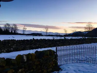 a fence in a field with snow on the ground at 1 Bed in Ullswater 94064 in Watermillock