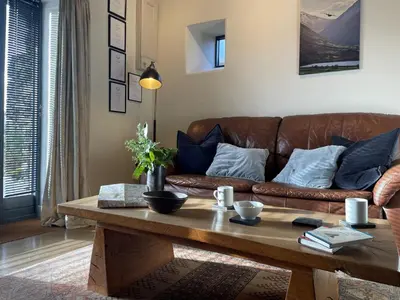 a living room with a brown couch and a coffee table at 1 Bed in Ullswater 94064 in Watermillock