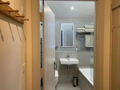 a bathroom with a sink and a toilet and a tub at 1 Bed in Watermillock 94068 in Watermillock