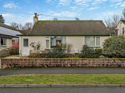 a white house with a brick retaining wall at 1 Bed in Keswick oc-94245 in Keswick