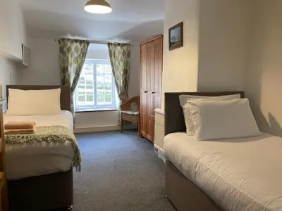 a bedroom with two beds and a window at Burnthwaite Farm B&B in Wasdale