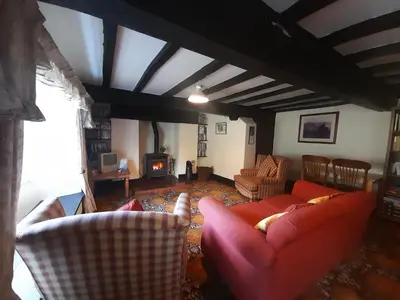 a living room with a red couch and a fireplace at Burnthwaite Farm B&B in Wasdale