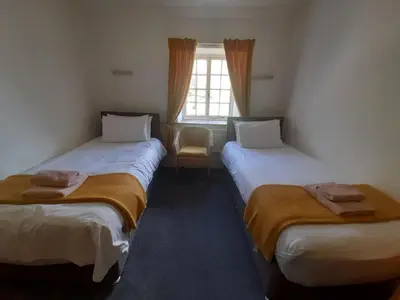 two beds in a room with a window at Burnthwaite Farm B&B in Wasdale