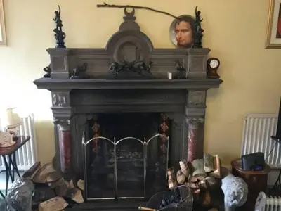 a fireplace with a portrait on top of it at Kirkconnel Hall Hotel in Lockerbie