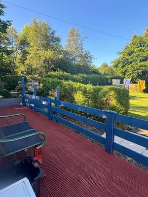 a bench on a wooden deck with a fence at 2 bedroom static caravan in Muirkirk