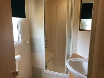 a bathroom with a shower and a sink and a toilet at 2 bedroom static caravan in Muirkirk