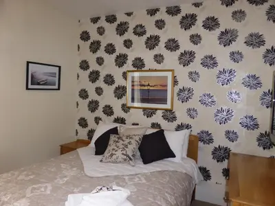 a bedroom with a bed with a flowery wallpaper at Bailey Ground Lodge in Seascale