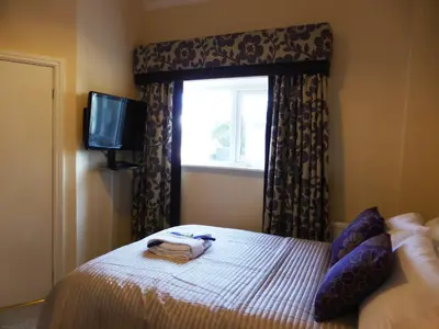 a bedroom with a bed with a window and a television at Bailey Ground Lodge in Seascale