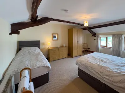 a bedroom with two beds and a dresser at Bassenthwaite Farm Cottage, on a working farm in a tranquil setting in Bassenthwaite