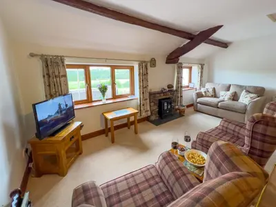 a living room with a couch and a tv at Fell View Bassenthwaite, rural location on a working farm in the fells in Bassenthwaite