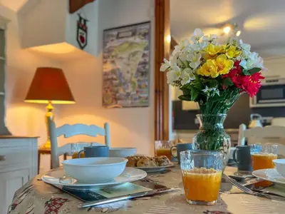 a table with a vase of flowers and a vase of juice at Fell View Bassenthwaite, rural location on a working farm in the fells in Bassenthwaite