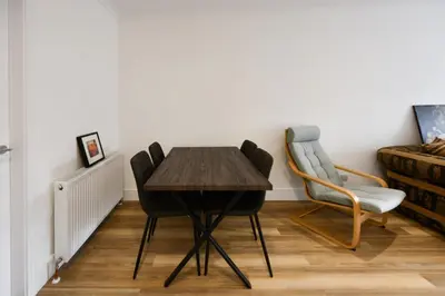 a dining room with a wooden table and two chairs at Troon Portland Apt B in Troon
