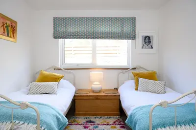 two twin beds in a room with a window at The Well in Mainsriddle