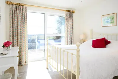 a bedroom with a bed and a large window at The Well in Mainsriddle