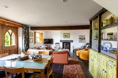 a living room with a table and a couch at HIGH TREES BYRE - Two bed Cottage with Log Burner & Incredible Views in Workington