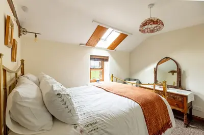 a bedroom with a bed and a desk and a mirror at HIGH TREES BYRE - Two bed Cottage with Log Burner & Incredible Views in Workington