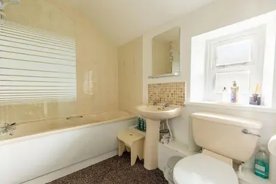 a bathroom with a tub and a sink and a toilet at HIGH TREES BYRE - Two bed Cottage with Log Burner & Incredible Views in Workington