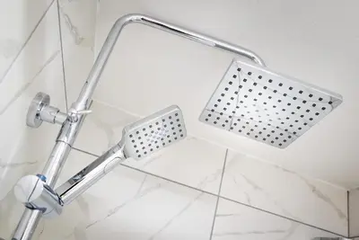 a shower head in a bathroom with white tiles at Kings Arms Suites - Deluxe Room - En-Suite - Self Check In in Whitehaven