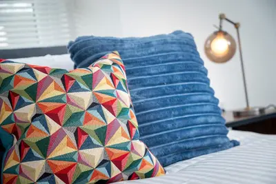a bed with two pillows and a blue pillow at Kings Arms Suites - Deluxe Room - En-Suite - Self Check In in Whitehaven