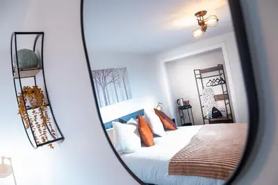a reflection of a bedroom with a bed in a mirror at Kings Arms Suites - Luxury Double - Waterfall Shower - Self Check In in Whitehaven