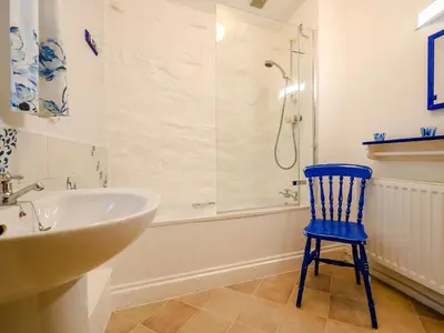 a blue chair in a bathroom with a shower at 3 Bed in Watermillock SZ318 in Watermillock