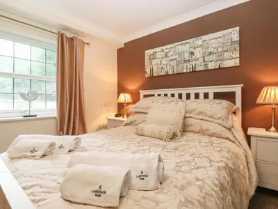 a bedroom with a bed with two pillows on it at 5 Ladstock Hall in Keswick